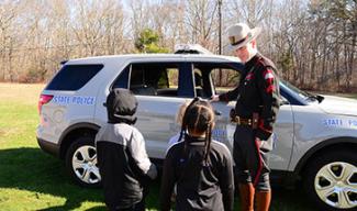 children looking at state police vehicle 