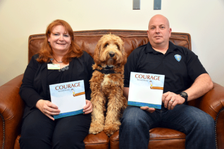 Dr. Christine Barron from Hasbro Children's Hospital, Detective Michael Iacone from Cranston Police and K-9 CALI reading "Courage"